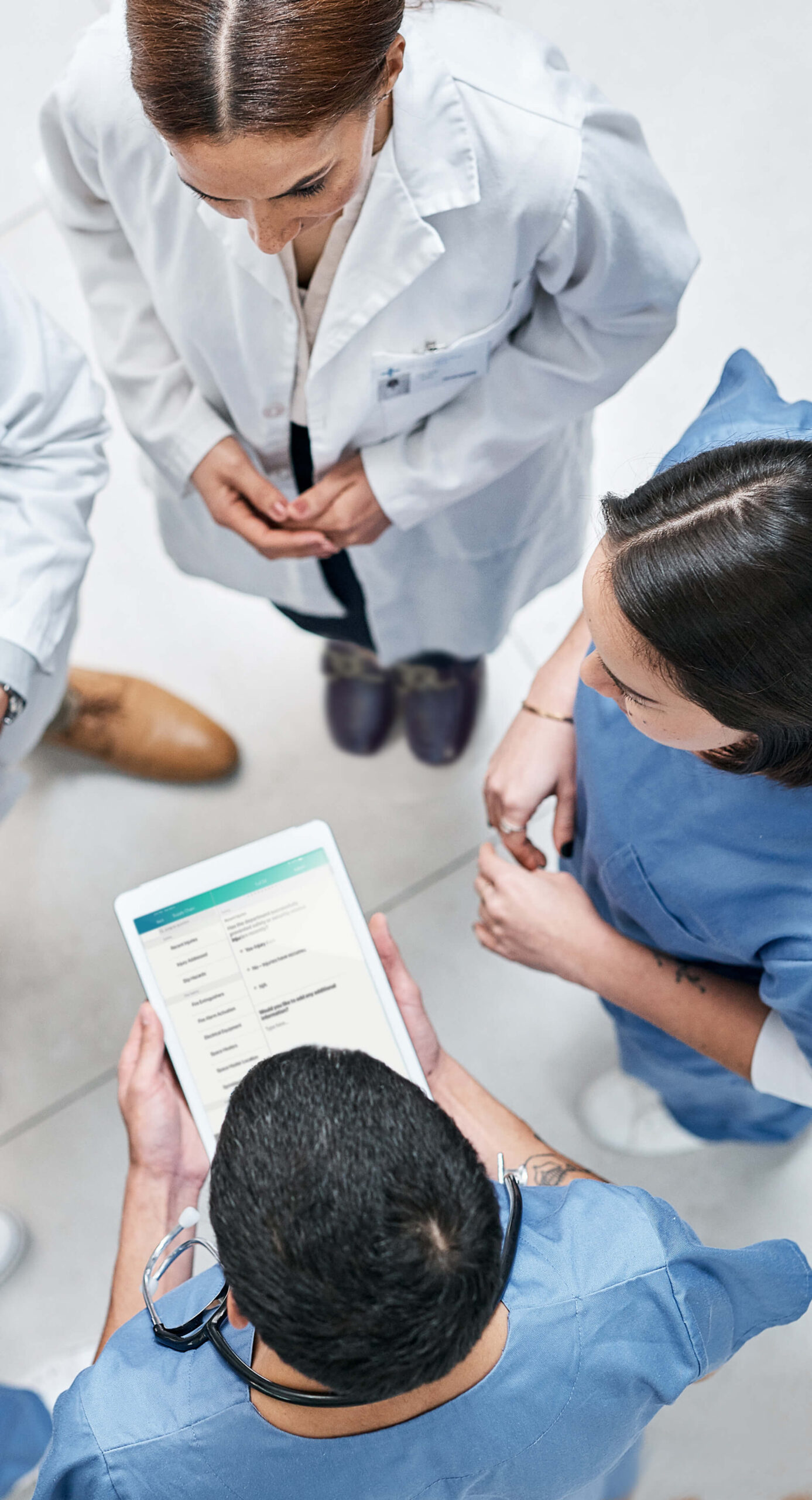 A team of nurses and doctors viewing health data on a tablet