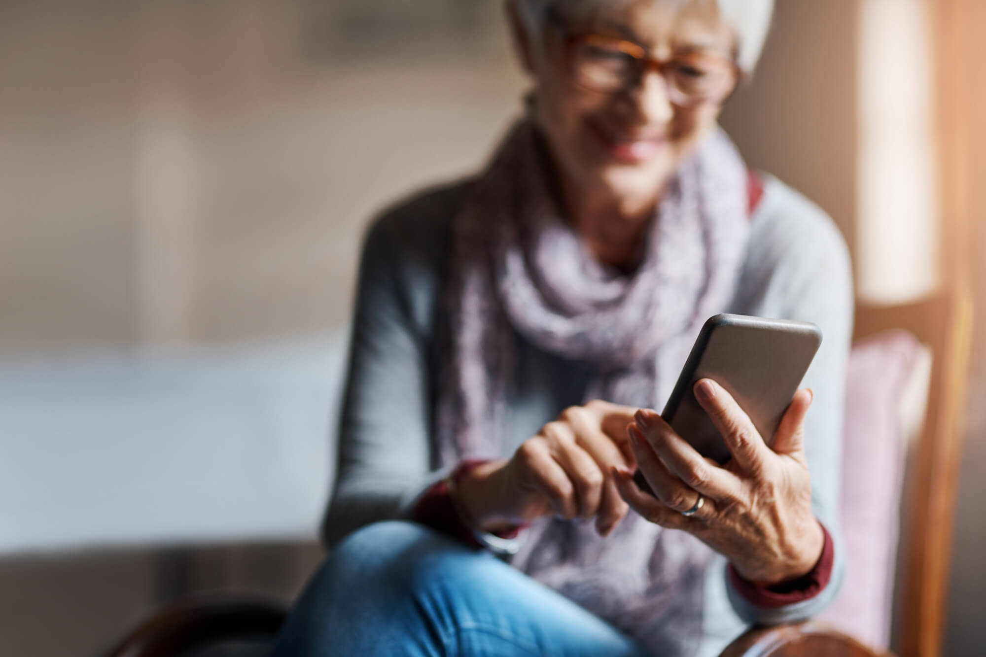 A woman smiling and viewing her Smartphone